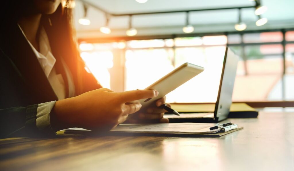 Zen 9 Marketing Digital marketing services woman looking at a tablet and laptop to boost marketing efforts