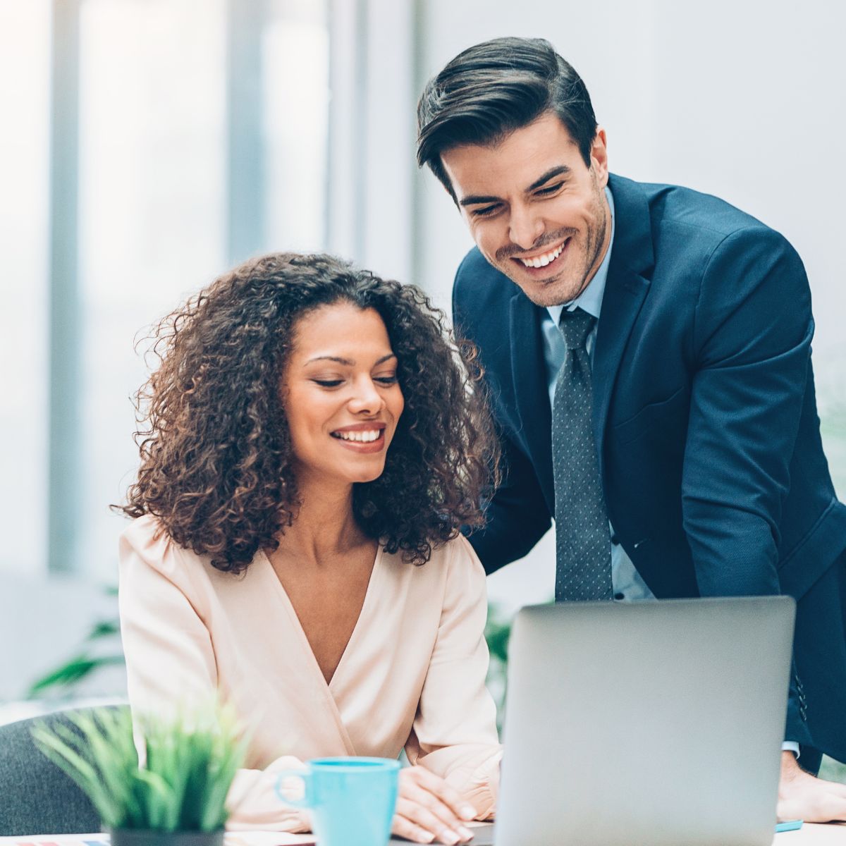 Canva-Zen 9 Marketing Square Two people in an office looking at a computer and discussing clients