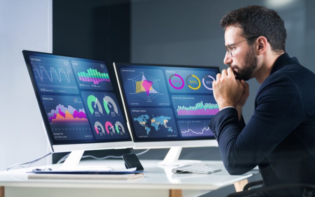 Canva-Zen 9 Marketing businessman sitting in front of a computer with dual monitors checking web analytics