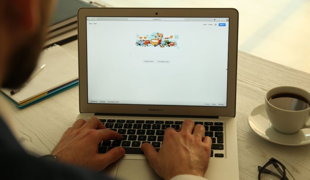 Canva-Zen 9 Marketing Man using a small laptop and performing a Google search