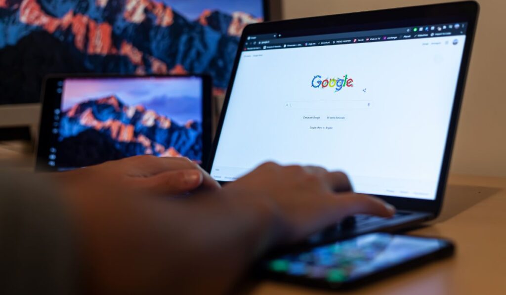 Canva-Zen 9 Marketing Person searching Google on a laptop with a tablet and a smartphone beside them
