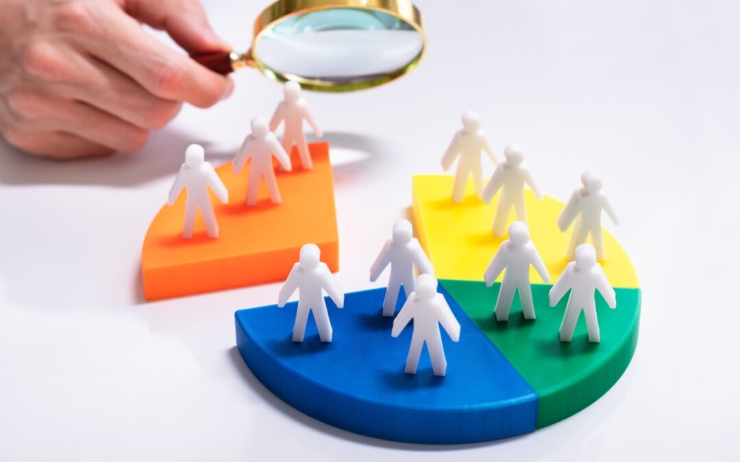 figures of customers on a pie chart being examined by a man holding a magnifying glass